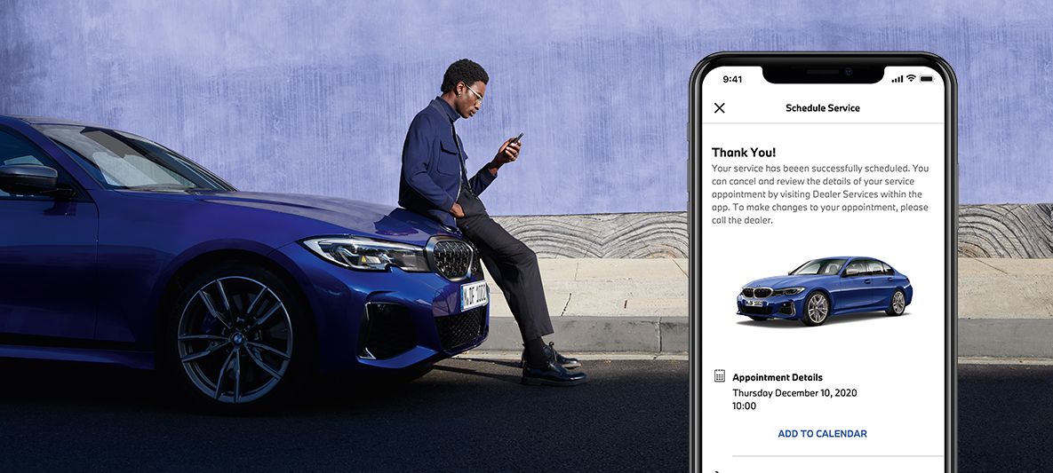 Gestion des besoins en entretien par l'App My BMW, un homme assis sur le capot d'une BMW