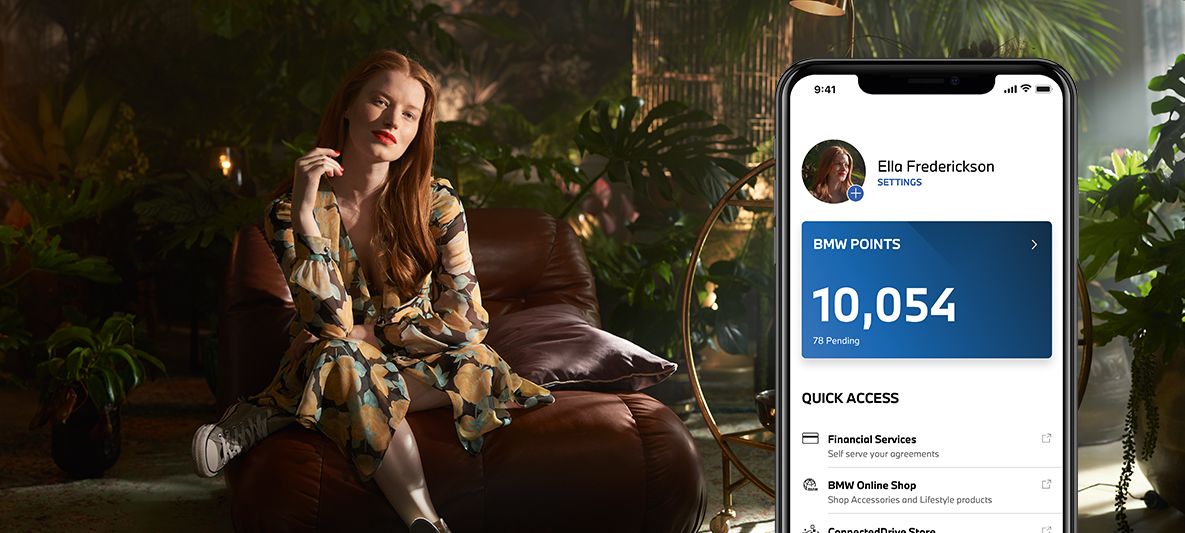 La conduite électrique et la collecte de BMW Points avec My BMW App, femme assise sur un siège devant des plantes